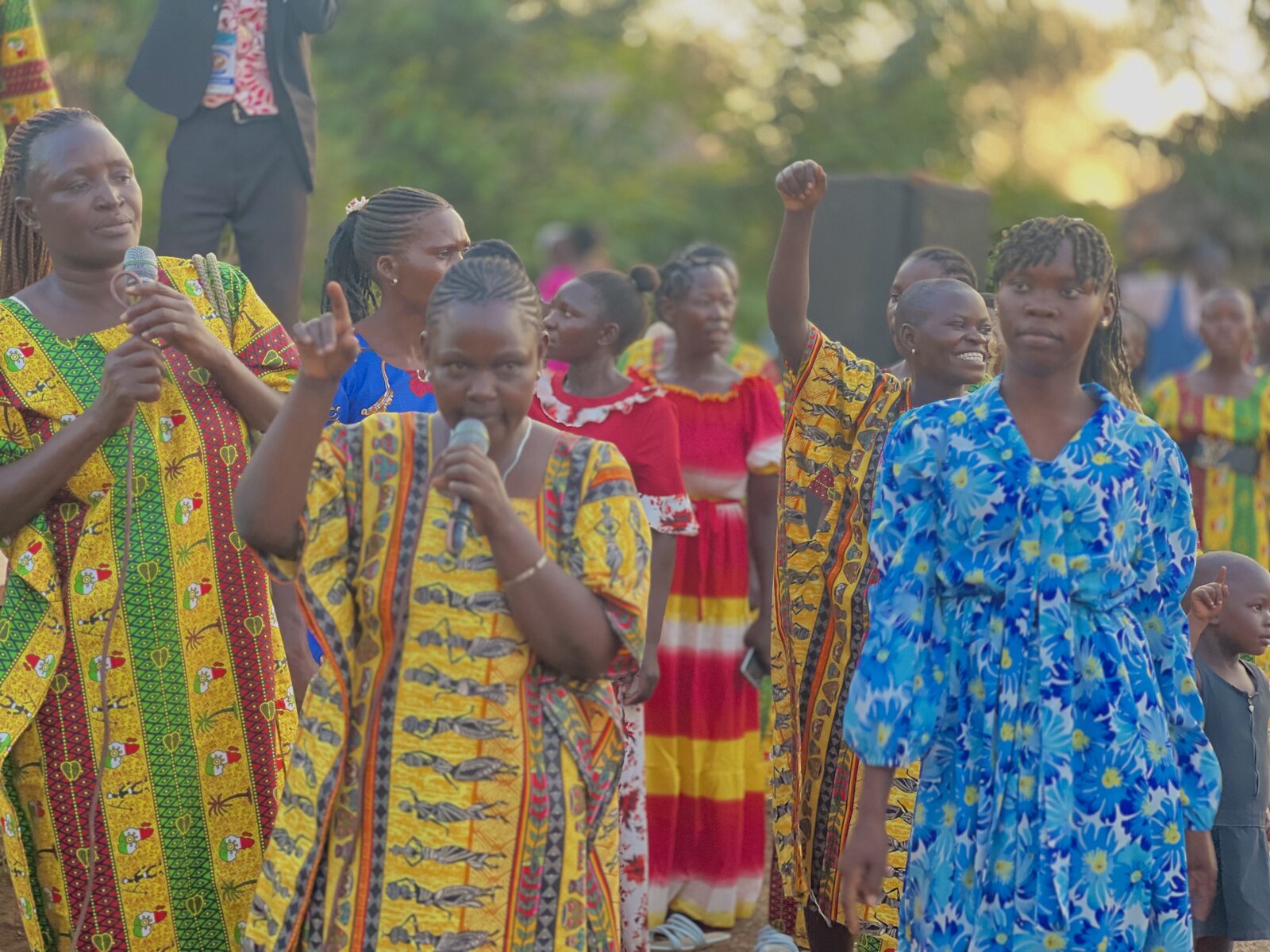 Women in colorful dresses leading worship at an open-air crusade